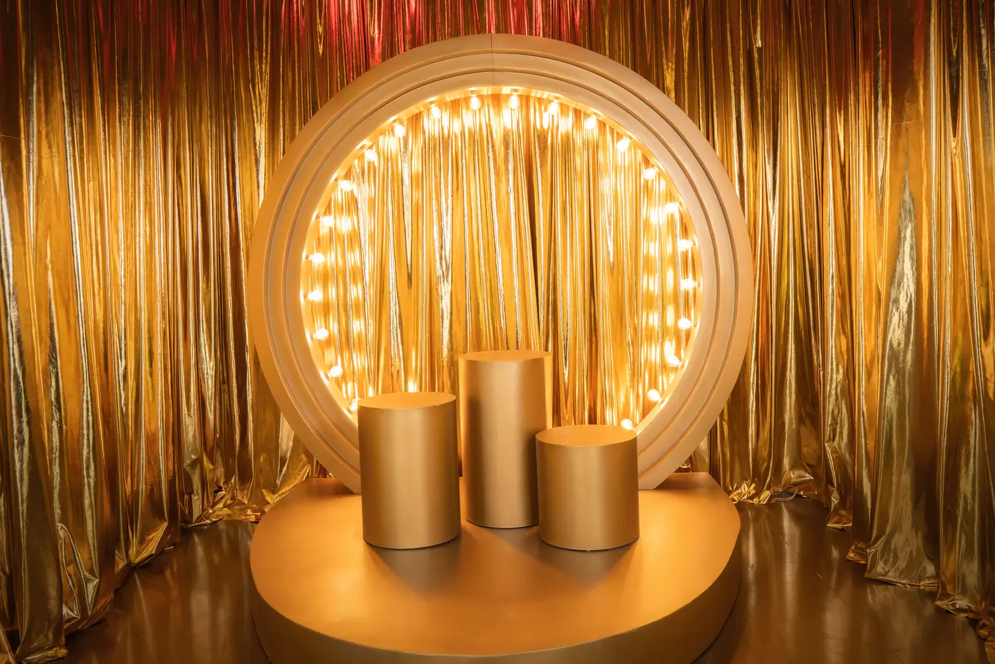 Escenario dorado con un aro iluminado y pedestales